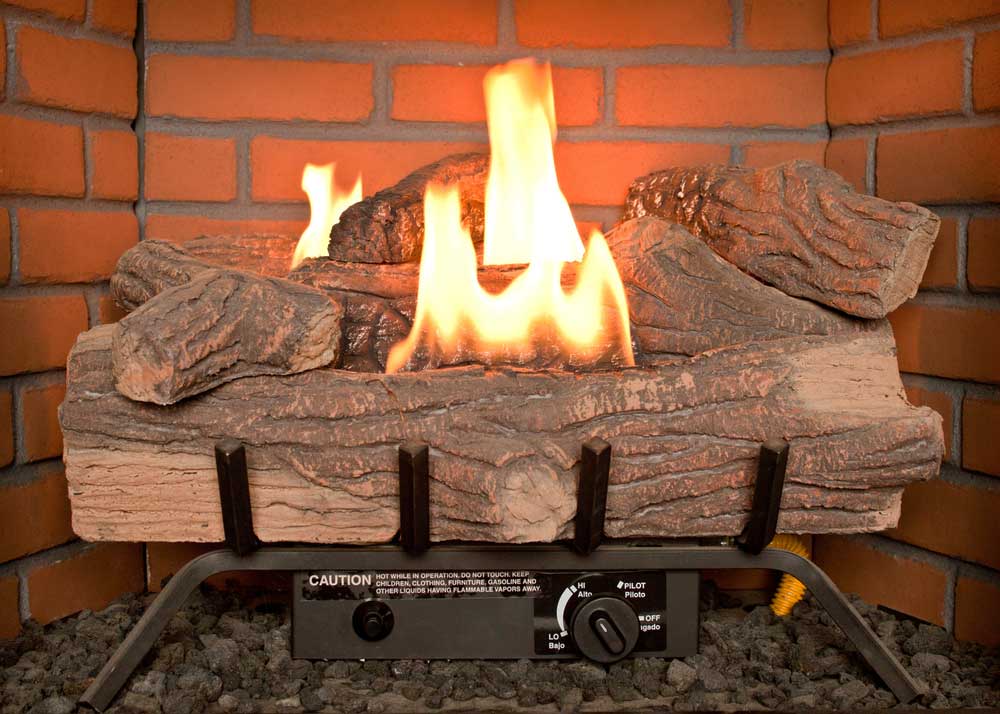 Gas logs with flames inside fireplace.