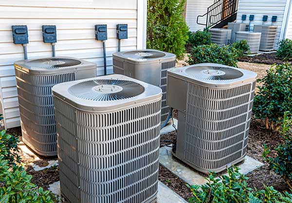 4 air conditioning units sitting outside a home